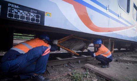 Petugas memeriksa bagian bawah gerbong yang rusak akibat anjloknya kereta api di Nagreg, Kabupaten Bandung, Jawa Barat, Selasa (4/6/2019).