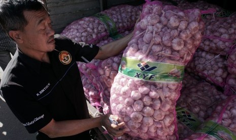 Petugas memeriksa bawang putih sitaan dari kegiatan razia satgas pangan, di Polres Cilacap, Jawa Tengah, Jumat (26/5). Satgas Pangan Polres Cilacap menyita 10 ton bawang putih yang telah disimpan selama satu bulan, oleh pedagang yang tidak dilengkapi dengan dokumen resmi dan tidak terdaftar sebagai distributor resmi di Disperindagkop Kabupaten Cilacap. ANTARA FOTO/Idhad Zakaria/foc/17. 