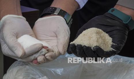 Petugas memeriksa gula rafinasi oplosan saat gelar perkara di Polresta Banyumas, Jawa Tengah, Kamis, (22/4/2021). Polresta Banyumas berhasil mengungkap sindikat pengoplos gula rafinasi industri dicampur molase yang kemudian dijual kembali sebagai gula konsumsi dan telah beroperasi selama tujuh bulan dengan kapasitas produksi mencapai 100 ton per bulan. 