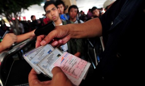 Petugas memeriksa kartu identitas dan tiket calon penumpang KA Mataremaja di Stasiun Senen, Jakarta.  (Edwin Dwi Putranto/Republika)