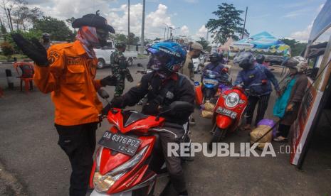 Petugas memeriksa kartu identitas pengendara saat penyekatan pemudik di Jalan Trans Kalimantan Kapuas, Kalimantan Tengah, Senin (3/5/2021). Penyekatan oleh petugas gabungan dari TNI, Polri, Dinas Perhubungan, Satpol PP dan BPBD tersebut untuk pemeriksaan protokol kesehatan COVID-19 serta memberikan arahan pemudik memasuki wilayah Kalteng wajib membawa hasil tes Antigen yang berlaku 3x24 jam.