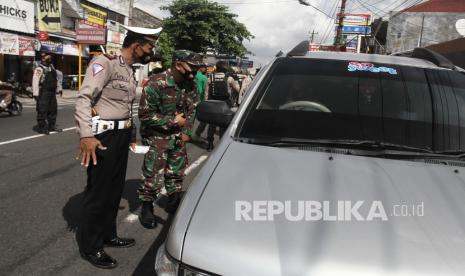 Petugas memeriksa kelengkapan surat saat penyekatan di Wirobrajan, Yogyakarta.  Lonjakan kasus terkonfirmasi positif di DIY dalam sepekan ini sangat memprihatinkan dengan tambahan di atas 400-500 per hari. Pemerintah Kota (Pemkot) Yogyakarta menegaskan, protokol kesehatan efektif tekan penyebaran Covid-19.