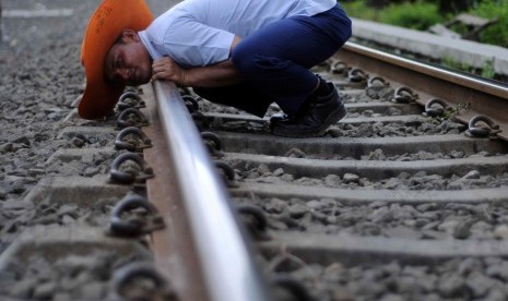 Petugas memeriksa kelurusan rel di ruas jalur kereta api Kampung Bandan - Muara Angke, Jakarta Utara, Ahad (15/4). (Republika/Wihdan Hidayat)