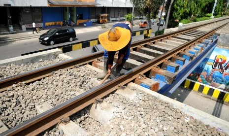 Petugas memeriksa kelurusan rel di ruas jalur kereta api Kampung Bandan - Muara Angke, Jakarta Utara, Ahad (15/4). (Republika/Wihdan Hidayat)