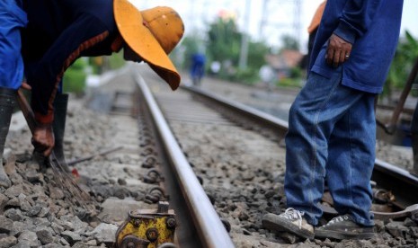 Petugas memeriksa kelurusan rel di ruas jalur kereta api Kampung Bandan - Muara Angke, Jakarta Utara, Ahad (15/4). (Republika/Wihdan Hidayat)