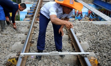 Petugas memeriksa kelurusan rel di ruas jalur kereta api Kampung Bandan - Muara Angke, Jakarta Utara, Ahad (15/4). (Republika/Wihdan Hidayat)