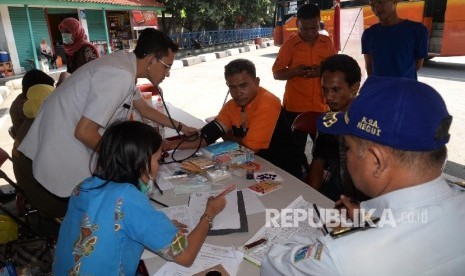 Petugas memeriksa kesehatan sopir angkutan Lebaran di posko kesehatan Terminal Kampung Rambutan, Jakarta, Jumat (24/6). (Republika/ Yasin Habibi)