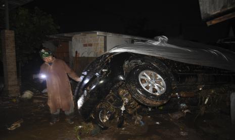 Petugas memeriksa kondisi kendaraan yang terbawa arus banjir bandang di Desa Mekarsari, Kecamatan Cicurug, Kabupaten Sukabumi, Jawa Barat, Senin (21/9/2020). Pada pukul 20.30, Pusat Pengendali Operasi (Pusdalops) BNPB mencatat sebanyak 12 rumah hanyut, 85 rumah terendam dan 1 unit mobil tersapu saat banjir bandang.