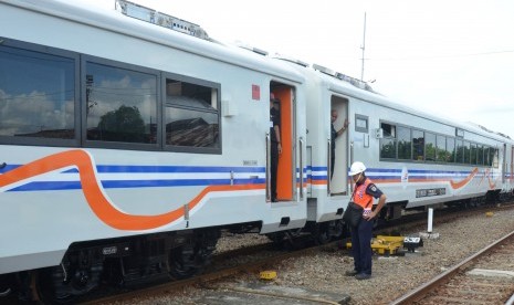 Petugas memeriksa kondisi kereta kelas ekonomi New Image sebelum dikirim di Stasiun Besar Madiun, Jatim. 