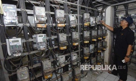 Petugas memeriksa meteran listrik di Rumah Susun Bendungan Hilir, Jakarta, Selasa (14/11). Pemerintah melalui Kementerian Energi dan Sumber Daya Mineral (ESDM) berencana melakukan penyederhanaan kelas golongan pelanggan listrik rumah tangga non-subsidi hanya menjadi dua golongan yaitu 4.400 VA dan 13.200 VA