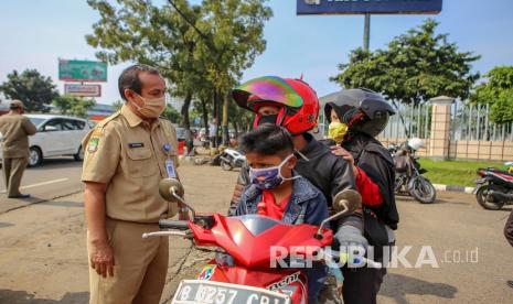 Hari Pertama PSBB Tangerang, Polisi Keluarkan 262 Teguran. Petugas memeriksa pengendara saat penerapan Pembatasan Sosial Berskala Besar (PSBB) di jalan M.H Thamrin, Cikokol, Kota Tangerang, Banten, Sabtu (18/4/2020). 