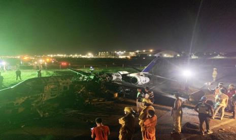 Petugas memeriksa pesawat carter Lionair yang jatuh di Bandara Internasional Ninoy Aquino (NAIA) pada Ahad (29/3). Seluruh penumpang pesawat dikabarkan tak selamat.