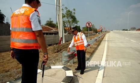 Petugas memeriksa rambu-rambu di jalan tol Brebes Timur-Tegal-Pemalang saat uji layak operasi di Desa Kalimati, Adiwerna, Kabupaten Tegal, Jawa Tengah, Senin (21/5). 