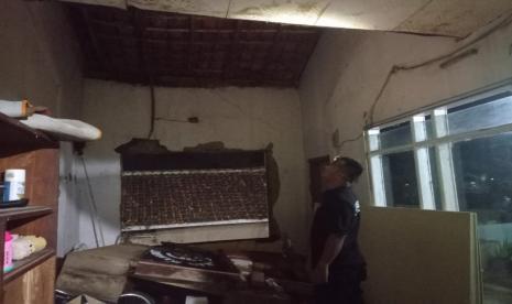 Petugas memeriksa rumah warga yang mengalami kerusakan akibat diterjang hujan deras disertai angin puting beliung di Desa Leles, Kecamatan Leles, Kabupaten Garut, Senin (24/1/2022). 