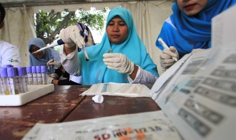 Petugas memeriksa sampel darah saat pemeriksaan HIV/AIDS gratis dalam rangka memperingati hari AIDS sedunia di Indramayu, Jawa Barat, Sabtu (1/12/2018). 