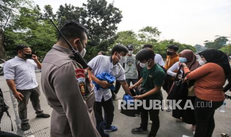 Petugas memeriksa sejumlah remaja saat melintasi perbatasan Depok-Jakarta di Flyover UI, Depok, Jawa Barat, Senin (11/4/2022). Polres Metro Kota Depok melakukan pengamanan di empat titik perbatasan menuju Jakarta untuk mengantisipasi massa yang akan berunjuk rasa di Gedung DPR/MPR. 