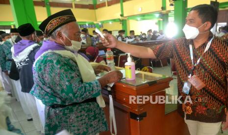 Petugas memeriksa suhu tubuh jamaah calon haji sebelum pengecekan kesehatan di Asrama Haji Donohudan, Boyolali, Jawa Tengah, Jumat (3/6/2022). Petugas kesehatan di Asrama Haji Donohudan memeriksa dokumen riwayat vaksinasi Covid-19 dan kondisi kesehatan terakhir calon haji sebelum bertolak ke tanah suci pada Sabtu (4/6/2022) dini hari .