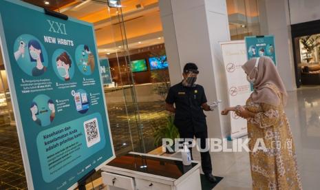 Petugas memeriksa suhu tubuh pengunjung sebelum memasuki area di salah satu bioskop, di Kota Banjarmasin, Kalimantan Selatan, Senin (19/10/2020). Pemerintah daerah setempat mengizinkan bioskop beroperasi kembali dengan menerapkan protokol kesehatan yang ketat guna mencegah penyebaran pandemi COVID-19 di lingkungan bioskop.