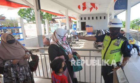 Petugas memeriksa suhu tubuh penumpang sebelum menaiki Kereta Api Sibinuang jurusan Padang - Pariaman, di Stasiun Tabing, Padang, Sumatera Barat, Sabtu (1/8/2020). PT KAI Divre II Sumbar kembali membuka perjalanan kereta api rute Padang - Naras (Pariaman) dengan memberlakukan protokol COVID-19 di antaranya penumpang diwajibkan menggunakan masker dan diimbau memakai pakaian lengan panjang serta menjaga jarak.