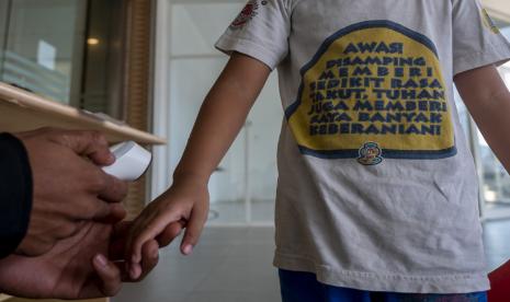 Petugas memeriksa suhu tubuh seorang anak sebelum memasuki kawasan perbelanjaan di Palu, Sulawesi Tengah, Kamis (24/6/2021). Sejumlah lembaga penelitian bidang kesehatan memperingatkan kerentanan anak terinfeksi COVID-19 yang saat ini berasio 1 : 9 kasus akan meningkat setelah ditemukannya varian baru B16.17 atau Varian Delta.