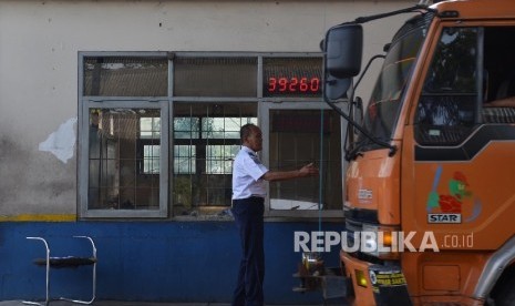 Petugas memeriksa surat-surat kendaraan di jembatan timbang Losarang, Indramayu, Jawa Barat, Senin (20/6). (Republika/Raisan Al Farisi)