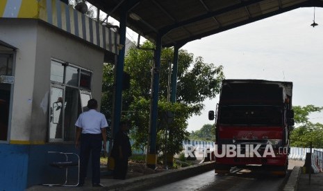 Petugas memeriksa surat-surat kendaraan di jembatan timbang Losarang, Indramayu, Jawa Barat, Senin (20/6). (Republika/Raisan Al Farisi)