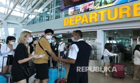 Petugas memeriksa tiket calon penumpang di Terminal Keberangkatan Internasional Bandara Internasional I Gusti Ngurah Rai, Bali, Selasa (4/2/2020). 