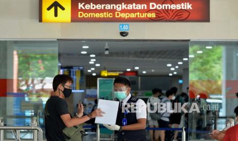 Petugas memeriksa tiket calon penumpang pesawat udara di area Terminal Keberangkatan Domestik Bandara Internasional I Gusti Ngurah Rai, Bali, Ahad (2/1/2022). Pengelola Bandara I Gusti Ngurah Rai memperkirakan puncak arus balik libur Hari Raya Natal 2021 dan Tahun Baru 2022 terjadi pada Minggu (2/1) dengan perkiraan sekitar 15 ribu orang penumpang yang meninggalkan Bali menuju berbagai kota di Indonesia.