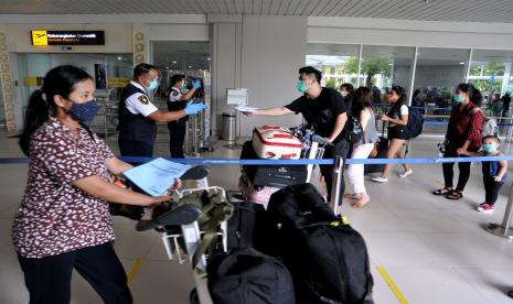 Petugas memeriksa tiket calon penumpang pesawat udara di Terminal Domestik Bandara Internasional I Gusti Ngurah Rai, Bali. Pengetatan pembatasan membuat aturan perjalanan di Jawa Bali turut diketatkan, dengan keharusan tes antigen dan PCR.