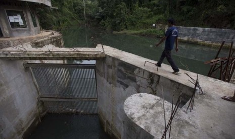 Petugas memeriksa tinggi debit air dari Kali Segara yang menuju ruang turbin Pembangkit Listrik Tenaga Mini Hidro (PLTMH) Segara di Bendungan Air di Desa Bentek, Gondang, Lombok Utara, NTB, Senin (8/12).