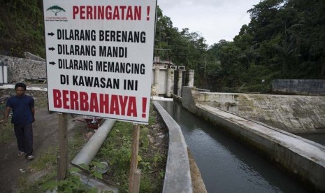 Petugas memeriksa tinggi debit air dari Kali Segara yang menuju ruang turbin Pembangkit Listrik Tenaga Mini Hidro (PLTMH) Segara di Bendungan Air di Desa Bentek, Gondang, Lombok Utara, NTB, Senin (8/12).