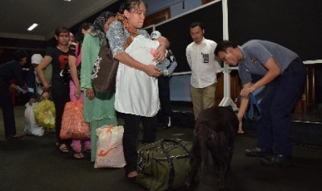 Petugas memeriksa TKI ilegal dari Malaysia di Lanud Halim Perdanakusuma, Jakarta, Selasa (23/12).