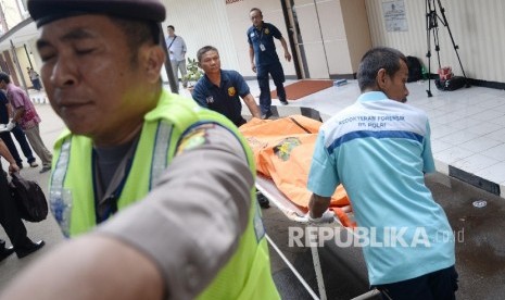 Petugas memindahkan jenazah korban serangan teror di Jalan MH Thamrin ke kamar jenazah RS Polri, Jakarta, Jumat (15/1). (Republika/Yasin Habibi)