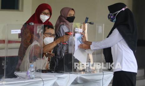 Petugas memindai kartu peserta seleksi kompetensi dasar (SKD) calon pegawai negeri sipil (CPNS) sebelum memasuki ruangan tes di Convention Hall Simpang Lima Gumul, Kediri, Jawa Timur, Sabtu (11/9/2021). Rekrutmen aparatur sipil negara tahun 2021 sebanyak 1,3 juta formasi guna memenuhi kebutuhan instansi pemerintah di pusat dan daerah.