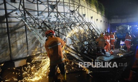 Petugas memotong reruntuhan papan reklame yang menutupi underpass Pasar Minggu arah selatan, Sabtu (24/9)