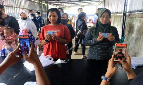 Petugas memotret identitas penerima manfaat Bantuan Langsung Tunai (BLT) Bahan Bakar Minyak (BBM) saat penyaluran di Kantor Pos Indramayu, Jawa Barat, Kamis (15/9/2022). Kementerian Sosial menyalurkan BLT pengalihan subsidi BBM kepada 20,65 juta keluarga penerima manfaat (KPM) senilai Rp12,4 triliun melalui PT Pos Indonesia. 