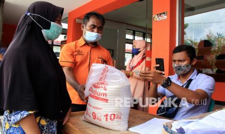 Petugas memotret kartu identitas warga penerima bantuan sosial (bansos) beras dari pemerintah di Kantor Pos Bagansiapiapi, Rokan Hilir, Riau, Selasa (10/8/2021). 