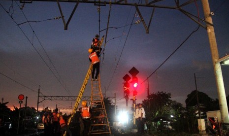 Petugas memperbaiki kabel listrik aliran atas yang mengalami korsleting di lintasan kereta api Tambun-Bekasi, Jawa Barat, Selasa (2/4).