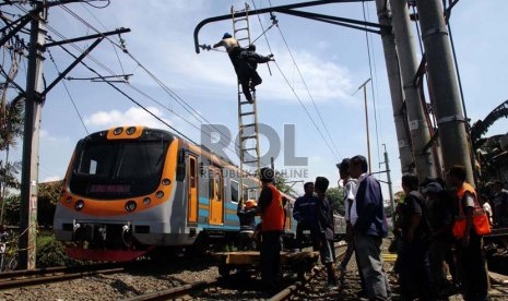  Petugas memperbaiki kabel listrik yang rusak akibat tabrakan kereta api dengan truk tangki di perlintasan kereta di Bintaro Permai, Jakarta Selatan, Selasa (10/12).   (Republika/Yasin Habibi)