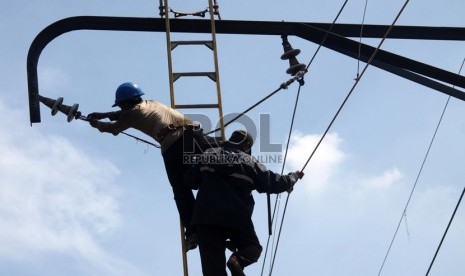  Petugas memperbaiki kabel listrik yang rusak akibat tabrakan kereta api dengan truk tangki di perlintasan kereta di Bintaro Permai, Jakarta Selatan, Selasa (10/12).   (Republika/Yasin Habibi)