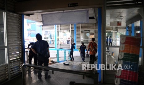 Petugas memperbaiki kerusakan halte bus way Transjakarta, Kampung Melayu, Jakarta timur, Jumat (26/4). 