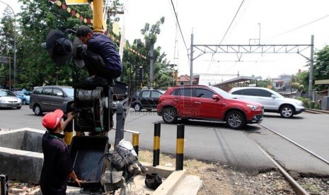 Petugas memperbaiki palang pintu kereta api di Grogol, Jakarta Barat, Senin (1/9). (Republika/ Yasin Habibi)