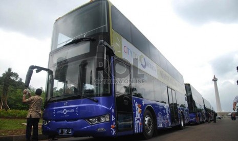  Petugas mempersiapkan armada bus tingkat pariwisata di kawasan Monas, Jakarta Pusat , Kamis (16/1).   (Republika/Rakhmawaty La'lang)