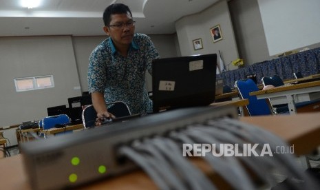 Petugas mempersiapkan peralatan untuk Ujian Nasional Berbasis Komputer (UNBK) di SMP Negeri 12, Jakarta, Sabtu (7/5).