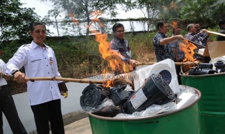  Petugas memusnahkan lampu dan pompa air listrik yang tidak sesuai Standar Nasional Indonesia (SNI) di halaman Gedung Kementerian Perdagangan, Jakarta, Kamis (29/10).  (Republika/Agung Supriyanto)