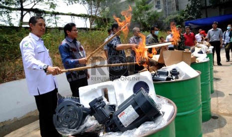 Petugas memusnahkan lampu dan pompa air listrik yang tidak sesuai Standar Nasional Indonesia (SNI) di halaman Gedung Kementerian Perdagangan, Jakarta, Kamis (29/10).