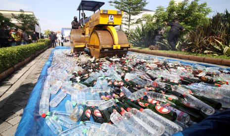 Petugas memusnahkan ribuan botol minuman keras saat pemusnahan barang bukti narkoba dan minuman keras di Polresta Sidoarjo, Jawa Timur, Rabu (29/12/2021). Polresta Sidoarjo memusnahkan barang bukti narkoba serta minuman keras diantaranya sabu seberat delapan kilogram, ganja seberat 5,5 kilogram, pil ekstasi sebanyak 159 butir, Pil dobel L sebanyak 754.360 butir serta minuman keras berbagai jenis, ukuran dan kemasan sebanyak 1.200 botol.