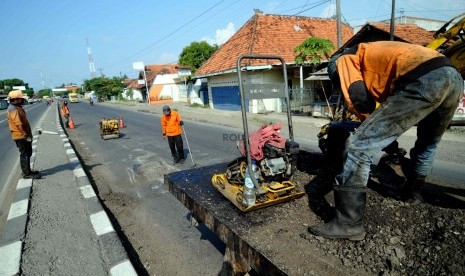 Petugas menambal jalan di Brebes, Jawa Tengah, Senin (21/7). (Republika/ Wihdan).