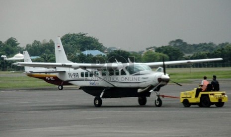   Petugas menarik sebuah pesawat di Bandara Halim Perdana Kusuma, Jakarta, Selasa (7/1).    (Republika/Yasin Habibi)