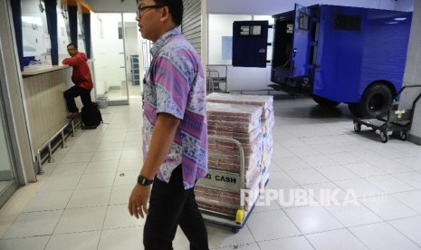 Petugas menarik troley berisi uang di Polling Cash Bank Mandiri, Jakarta, Kamis (9\2)